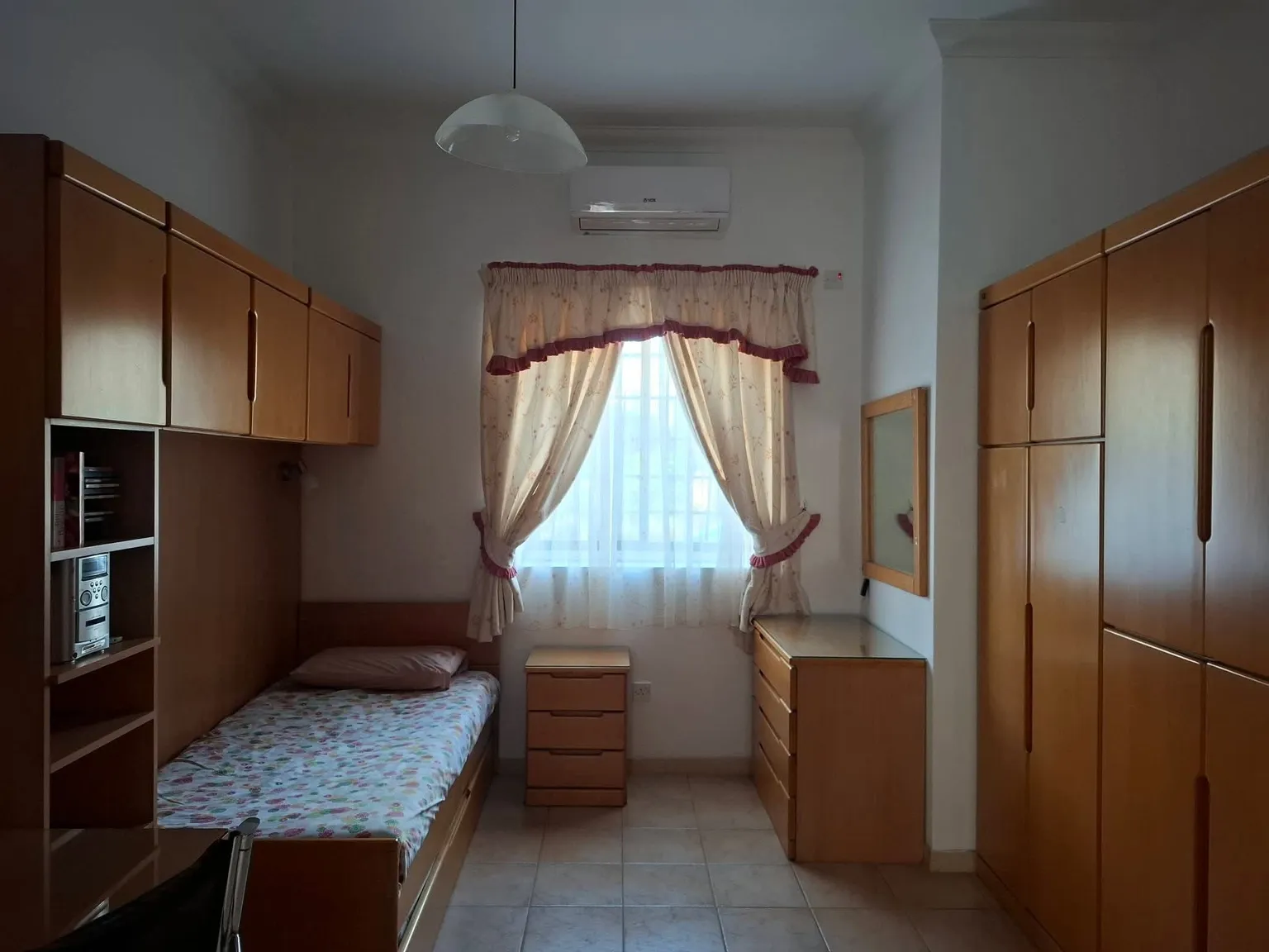 Furnished bedroom with fitted storage and air conditioning at the Gudja villa